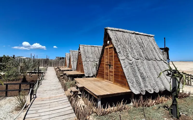 Cabañas tipo A-frame con techo de palma y terrazas de madera en el glamping Cubagua Lodge, isla de Cubagua, Nueva Esparta, Venezuela