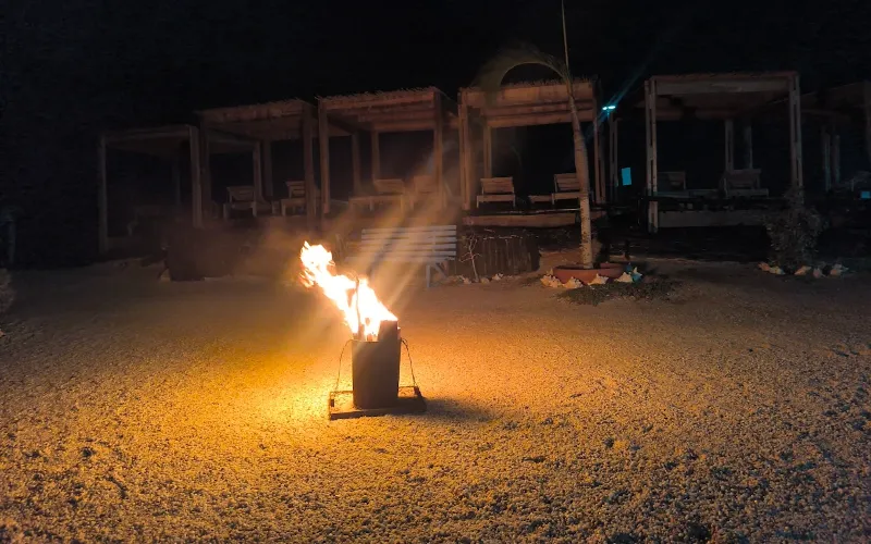 Fogata en la arena durante la noche frente a las instalaciones del glamping Cubagua Lodge, isla de Cubagua, Nueva Esparta, Venezuela