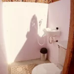 Baño privado con ducha, lavamanos y sanitario dentro de una cabaña del glamping Cubagua Lodge, isla de Cubagua, Nueva Esparta, Venezuela