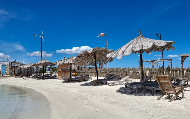 Bancas frente al mar turquesa con vista a la bahía desde el glamping Cubagua Lodge, isla de Cubagua, Nueva Esparta, Venezuela