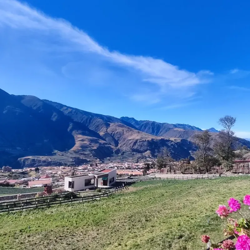 Vista panorámica del valle de Mucuchíes con cielo azul, flor de buganvilla y la cordillera andina desde la posada Rafaela y Cristóbal, Estado Mérida, Venezuela