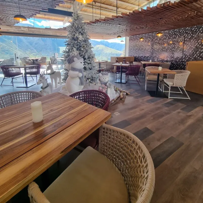 Restaurante interior de la posada Rafaela y Cristóbal con decoración navideña y vista panorámica a las montañas de Mucuchíes, Estado Mérida, Venezuela