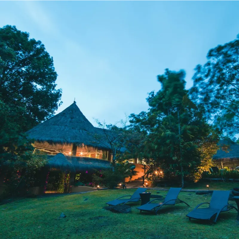 Vista nocturna de las cabañas con techo de palma y jardines iluminados del Waku Lodge frente a la Laguna de Canaima, Venezuela